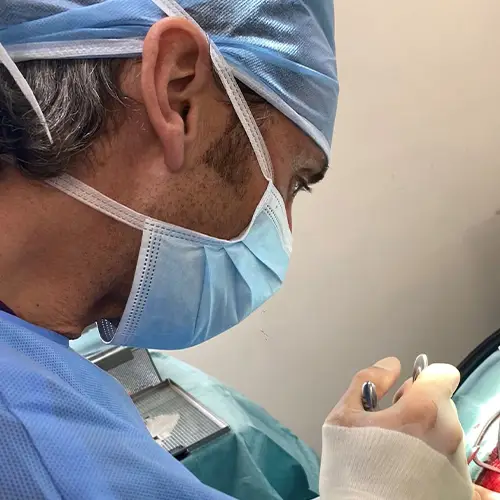 Dressed in blue scrubs and a mask, a surgeon concentrates intensely on the procedure, wielding surgical instruments with precision, much like the commitment observed among elite veterinary specialists during a specialised referral.